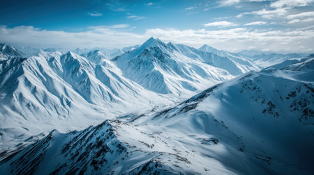 A breathtaking view of a snow-covered mountain range under a clear blue sky, showcasing the tranquility and beauty of winter landscapes in remote locations.の素材