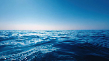 Experience the serene beauty of a vast ocean under a clear blue sky. Gentle waves create a calming atmosphere, perfect for nature-themed art projects or relaxation.の素材