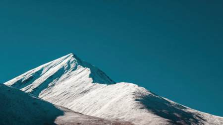 A stunning mountain peak covered in white snow under a clear blue sky, showcasing the beauty of nature. Perfect for themes of adventure and tranquility.の素材