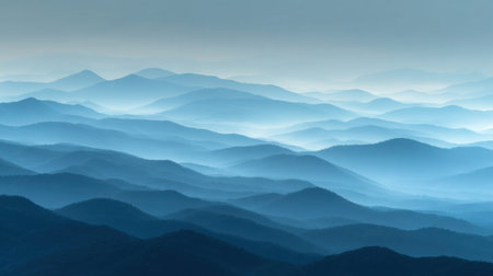 This stunning image showcases layers of misty blue mountains under soft morning light, creating a tranquil atmosphere that invites peace and contemplation.の素材