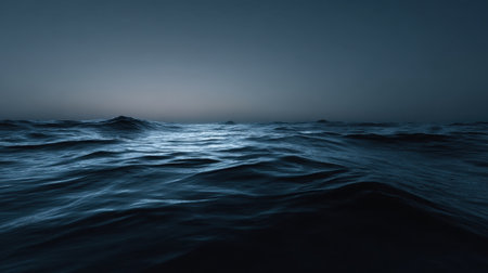 A serene view of gentle waves rippling across the ocean at dusk, showcasing deep blue hues. The tranquil atmosphere invites a sense of calm and reflection.の素材
