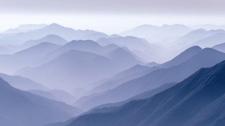 This image depicts a stunning view of layered mountains painted in soft blue tones. The mist envelops the peaks, creating a serene atmosphere perfect for nature lovers.の素材