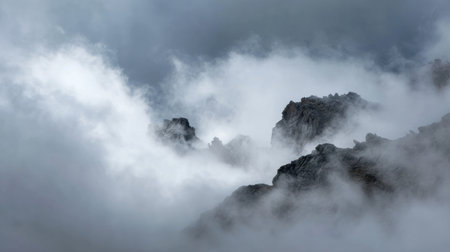 Experience the serene beauty of majestic mountain peaks enveloped in mystical clouds and fog, creating a captivating and atmospheric landscape perfect for nature lovers.の素材