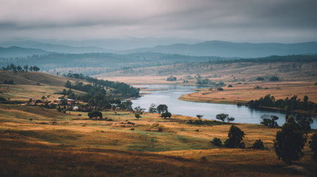 Discover a breathtaking river landscape featuring rolling hills and lush greenery, under a moody sky. A perfect escape for nature lovers and adventurers alike.の素材