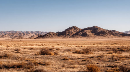 A stunning view of a vast arid landscape featuring mountains under an expansive blue sky, illustrating the beauty of nature in a serene desert environment.の素材