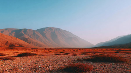 Discover a stunning desert landscape showcasing majestic mountains under a clear blue sky at dawn, embodying the tranquility and untouched beauty of nature's wonders.の素材