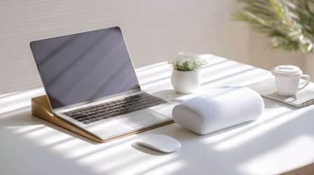 A serene home office scene with a laptop, mouse, white speaker, and coffee cup surrounded by soft natural lighting and a small potted plant, perfect for work or study.の素材