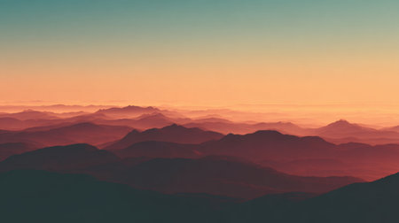 Experience the beauty of a serene sunrise over rolling mountains, where layers of fog create a tranquil landscape with soft color gradients and peaceful atmosphere.の素材