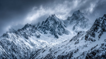 Breathtaking view of majestic snow-covered mountains under a stormy sky, showcasing rugged peaks amidst dark clouds and a captivating winter landscape.の素材