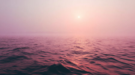 A captivating view of a serene sunset over calm ocean waters, showcasing soft pink hues and gentle waves that create a tranquil and peaceful atmosphere.の素材
