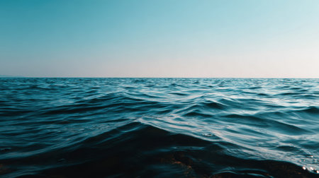 A serene view of tranquil blue ocean waters under a clear sky, showcasing gentle waves that reflect sunlight, perfect for relaxation and nature appreciation.の素材