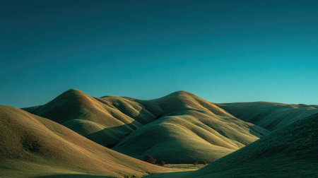 Beautiful landscape showcasing gentle rolling hills in vibrant green under a clear blue sky, inviting viewers to experience the tranquility and peace of nature's serenity.の素材