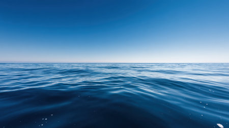 A vast and tranquil ocean surface meets a clear blue sky, showcasing gentle waves and a serene horizon. Ideal for relaxation and nature-themed projects.の素材