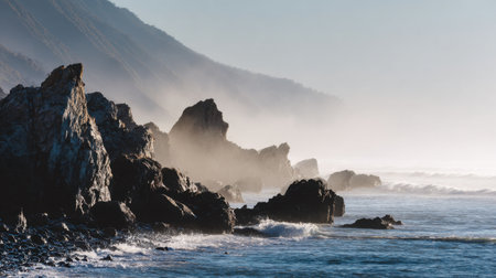 A peaceful coastal scene showcasing jagged rocks and gentle waves, enveloped in soft mist under a tranquil sunrise. Perfect for nature lovers and travel enthusiasts.の素材