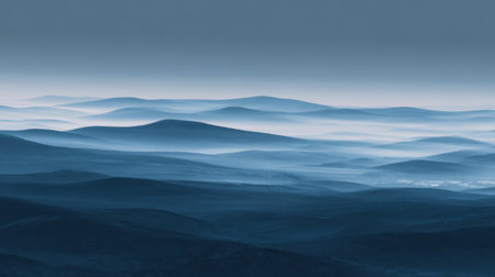A serene blue landscape showcasing soft rolling hills under a misty sky at dawn, evoking tranquility and calmness through cool tones and atmospheric depth.の素材