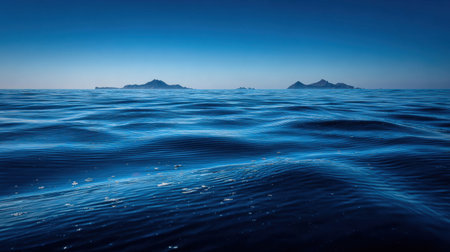 A stunning blue seascape showcasing gentle waves and distant islands beneath a clear sky. This image embodies the beauty of nature, evoking feelings of calmness and serenity.の素材
