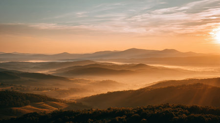 A stunning view of a sunrise illuminating rolling hills and misty valleys creates a serene atmosphere, showcasing the untamed beauty of nature at dawn.の素材