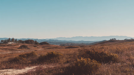 This beautiful landscape features rolling hills and distant mountains under a clear blue sky, showcasing the serene beauty of nature in an outdoor setting.の素材