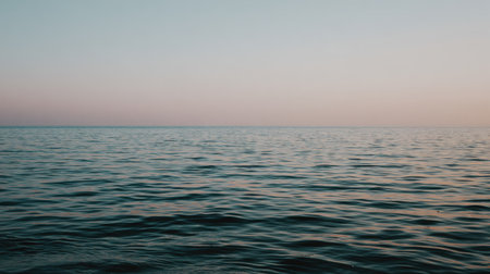 A tranquil ocean view captured at sunset, showcasing gentle waves and soft colors above. Ideal for evoking feelings of peace, relaxation, and escape into nature.の素材