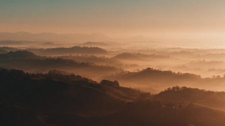 A breathtaking view of mist-covered hills bathed in soft dawn light, creating a serene atmosphere perfect for nature lovers and photographers seeking tranquility.の素材