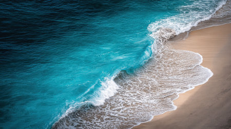 Experience a stunning coastal view with vibrant turquoise waves gently washing over a warm sandy beach. Ideal for evoking relaxation and natural beauty.の素材