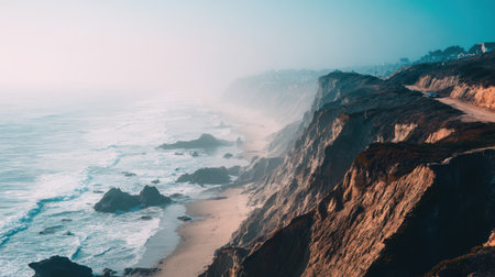 A captivating view of a misty coastal landscape, featuring rugged cliffs meeting gentle ocean waves. This serene scene evokes calmness and natural beauty.の素材