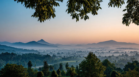 A breathtaking view of a misty landscape at sunrise showcases rolling mountains and lush greenery, creating a tranquil atmosphere perfect for nature lovers and travelers.の素材