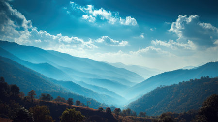 A stunning depiction of layered mountains enveloped in mist, showcasing a peaceful and serene natural environment under a beautiful blue sky.の素材
