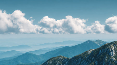 A breathtaking view of rolling mountain ranges beneath a vibrant sky filled with soft clouds. This serene landscape captures the essence of nature's beauty and tranquility.の素材
