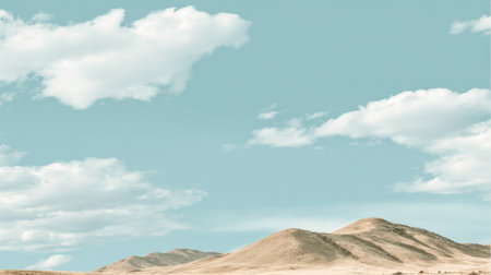 A captivating view of rolling hills beneath a clear blue sky adorned with soft white clouds, evoking a sense of calm and inviting exploration in a tranquil desert setting.の素材