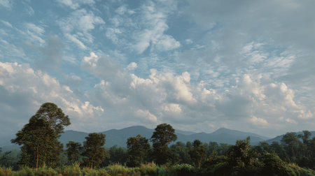 A breathtaking landscape captures lush green trees and rolling hills beneath a stunning cloudy sky, ideal for promoting nature and outdoor themes in photography.の素材