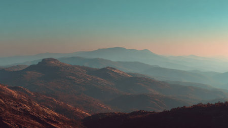 A breathtaking view of a mountain range at dusk, showcasing layered terrain and a tranquil atmosphere. The soft color palette enhances the serene beauty of the landscape.の素材
