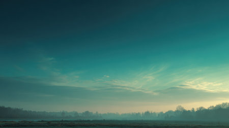 A mesmerizing view of a misty lake at dawn, featuring soft blue skies and gentle pastel hues. This tranquil scene captures the beauty of nature at its finest.の素材