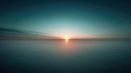 A stunning sunset illuminates the horizon over calm waters, creating a serene atmosphere. The gentle waves reflect soft colors, inviting relaxation and peace.の素材