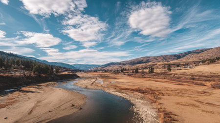 Experience a breathtaking river landscape featuring clear blue skies and rolling hills under fluffy clouds. Perfect for nature lovers and outdoor enthusiasts.の素材