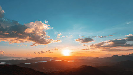 Experience the tranquil beauty of a stunning sunset over a majestic mountain range and serene lake, showcasing vibrant colors and peaceful atmosphere.の素材