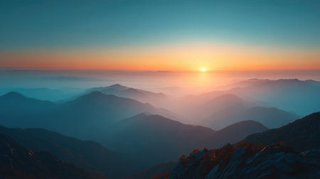 Experience the serene beauty of a breathtaking sunrise over majestic mountains. Soft blue and orange hues create a tranquil atmosphere filled with misty valleys.の素材