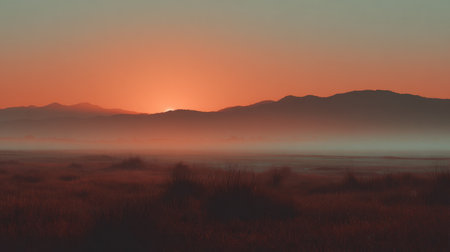 Experience the tranquil beauty of a serene sunset, where mist blankets the landscape and mountains create a dramatic silhouette, inviting peace and relaxation.の素材