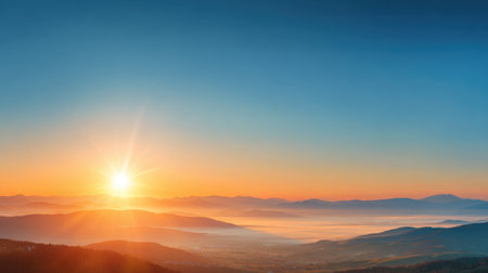 Experience the breathtaking beauty of a sunrise over hills and valleys. The serene moment highlights the vivid colors of the sky, providing a tranquil atmosphere.の素材