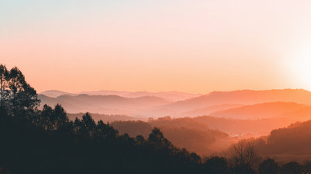 A breathtaking view of rolling mountains at sunrise, enveloped in soft fog, creates a tranquil outdoor scene perfect for relaxation and inspiration.の素材