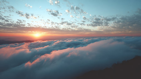 A stunning sunrise casts a warm glow over a sea of clouds, illuminating the sky in soft hues. This serene landscape invites peace and adventure in natureの素材
