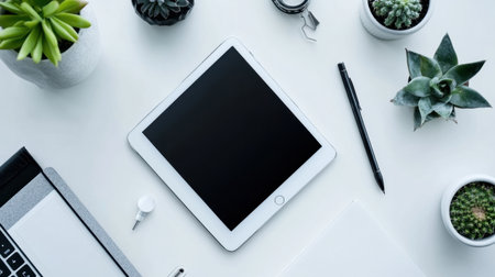 A clean and modern workspace featuring a tablet, various green plants, and stylish stationery items on a bright desk, perfect for enhancing productivity and creativity.の素材