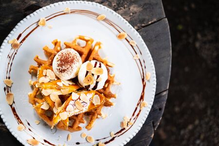 waffle topped with vanilla ice cream and banana slicesの写真素材