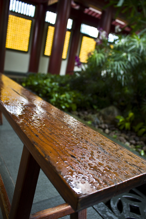 A wooden bench, wet from the rain in the Buddha Tooth Relic Temple, Singapore.