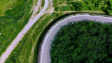 Aerial view of a road in the middle of the forest. Top view of asphalt road through forest with car adventure. Healthy environment road trip travel.の写真素材