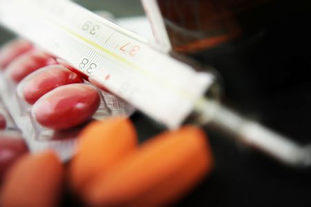 Thermometer with medication. Focus on thermometer