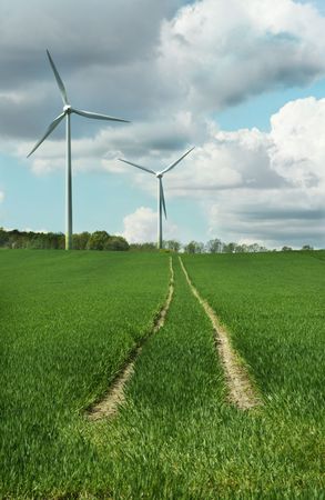 energy concept - wind turbines in beautiful summer landscape, amazing cloudscape