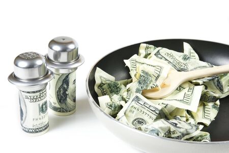 Abstract concept . Fried dollars in frying pan on white backgroundの写真素材