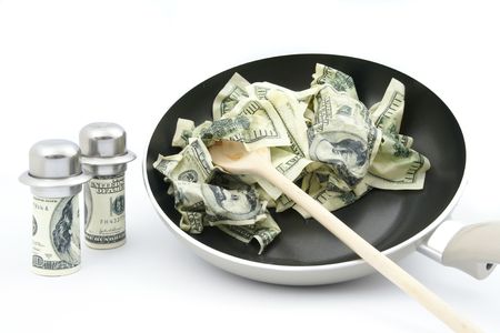 Abstract concept . Fried dollars in frying pan on white backgroundの写真素材