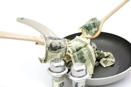 Abstract concept . Fried dollars in frying pan on white backgroundの写真素材